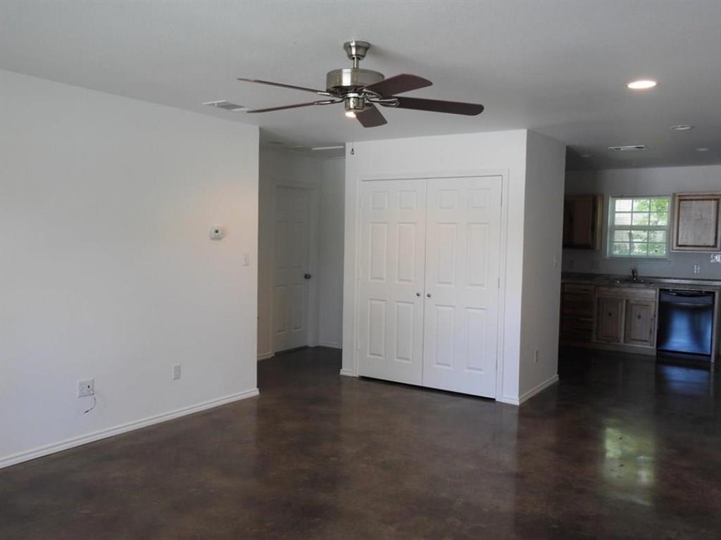 704 Seven Oaks Road Bonham, TX 75418 - Photo 7 of 11 an empty room with wooden floor and a ceiling fan