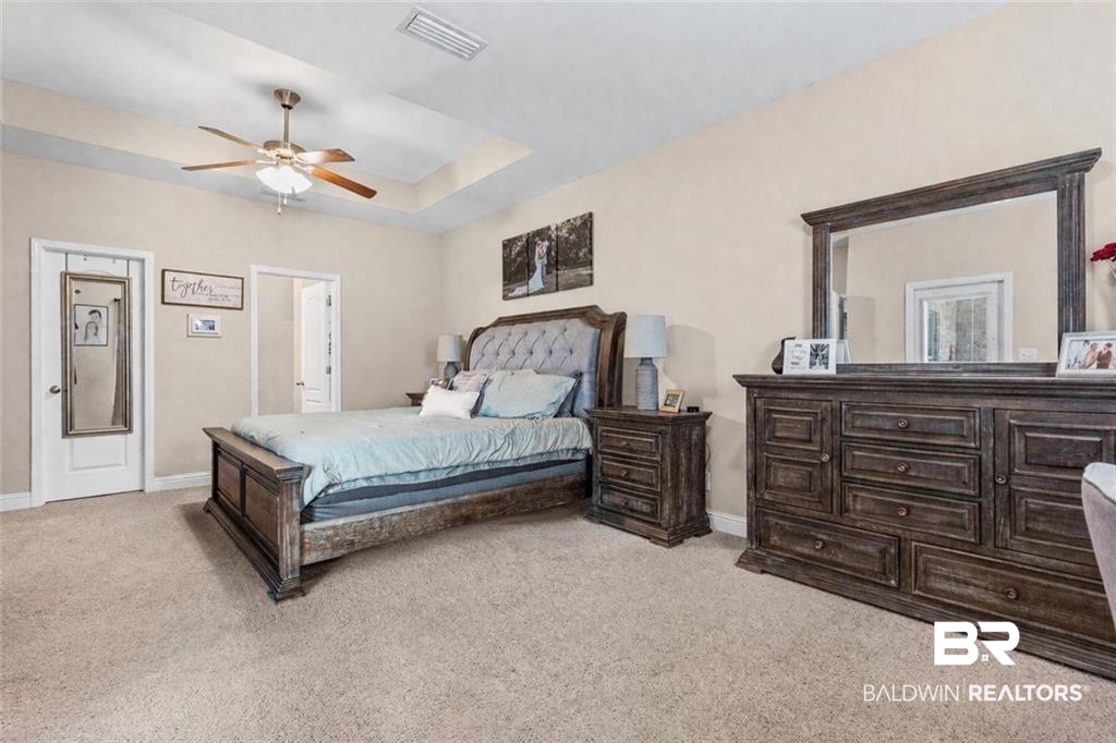 2570 Pecan Pointe Drive Semmes, AL 36575 - Photo 9 of 22 Bedroom featuring a raised ceiling, light colored carpet, and ceiling fan