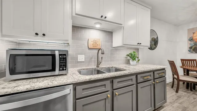 a kitchen with granite countertop a sink and cabinets