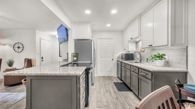 a kitchen with stainless steel appliances granite countertop a sink stove and refrigerator
