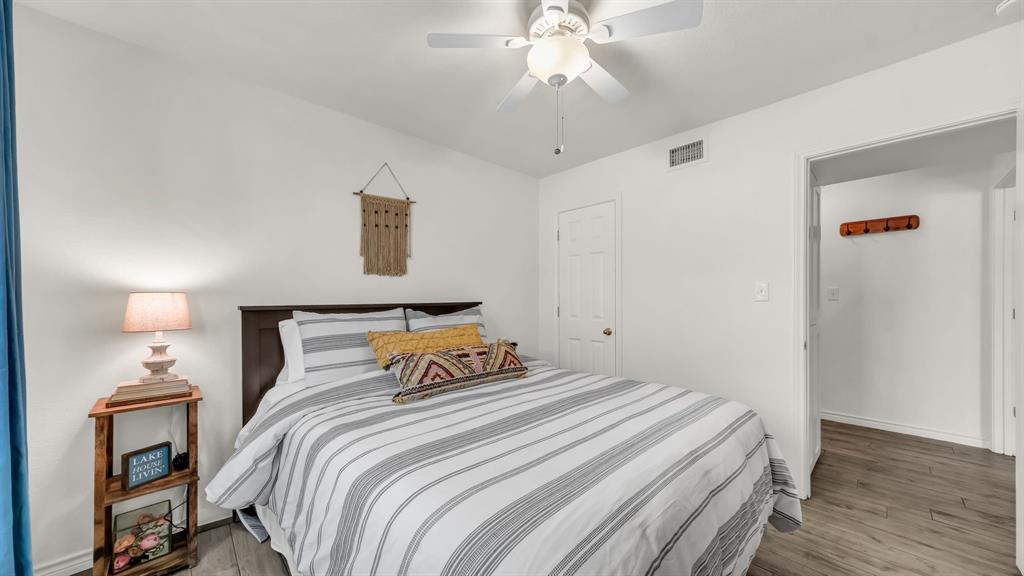 3059 Hells Gate Loop, Unit 7 Strawn, TX 76475 - Photo 18 of 36 a bedroom with a bed and wooden floor