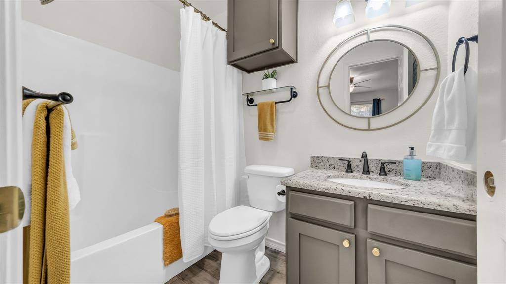 3059 Hells Gate Loop, Unit 7 Strawn, TX 76475 - Photo 26 of 36 a bathroom with a granite countertop toilet sink and mirror