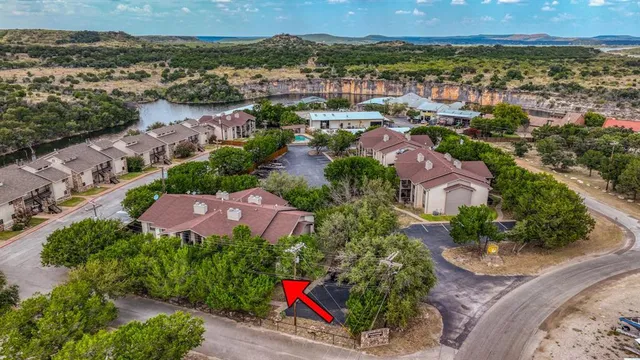 an aerial view of residential houses with outdoor space and trees