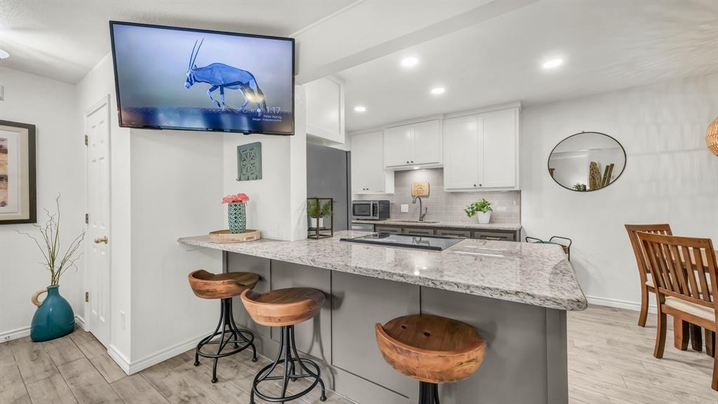 3059 Hells Gate Loop, Unit 7 Strawn, TX 76475 - Photo 8 of 36 a kitchen with stainless steel appliances granite countertop a sink a stove a dining table and chairs