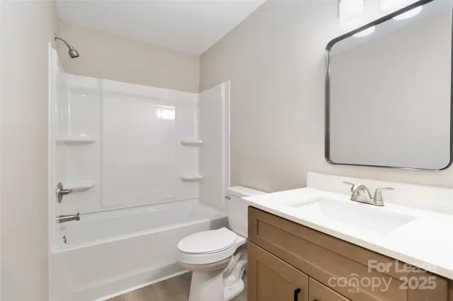 a bathroom with a sink toilet a mirror and shower