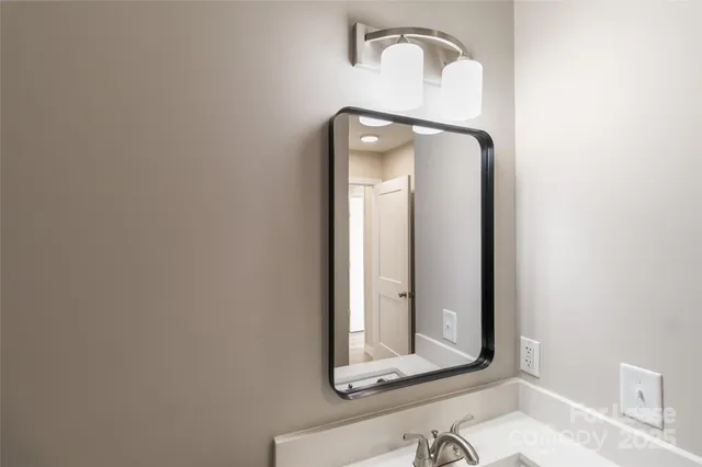 a bathroom with a mirror and vanity