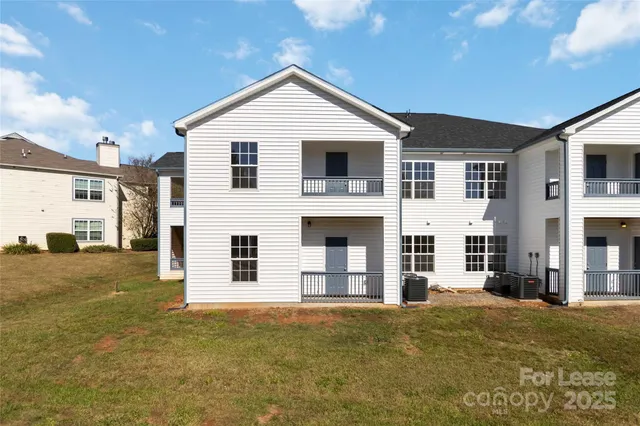 a view of a big house with wooden fence