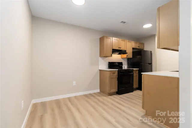 a kitchen with a sink a stove top oven a counter top space and cabinets