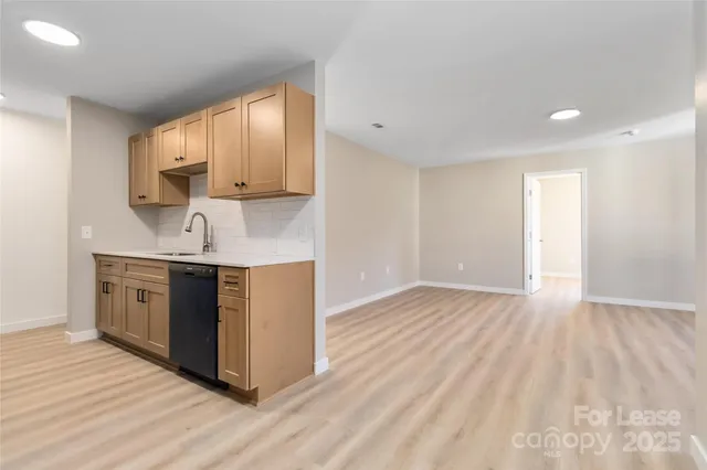 a kitchen with a sink cabinets and wooden floor