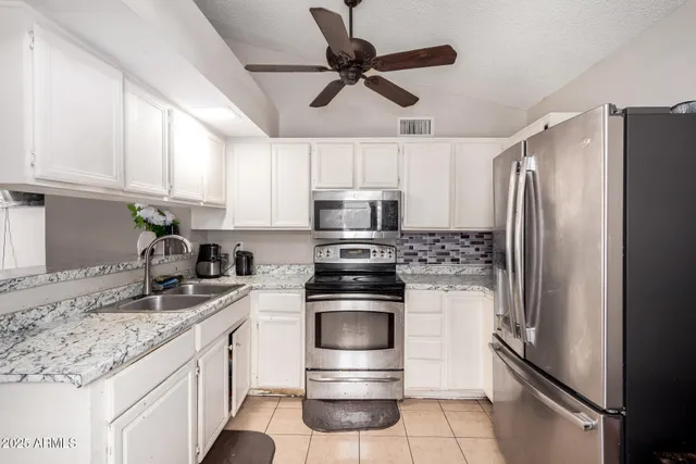 a kitchen with granite countertop a refrigerator and a sink