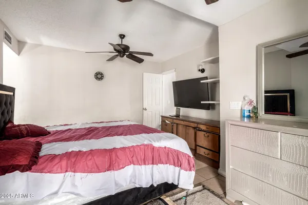 a bedroom with a bed and a flat screen tv