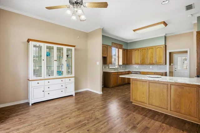 a kitchen with granite countertop a sink cabinets and wooden floor