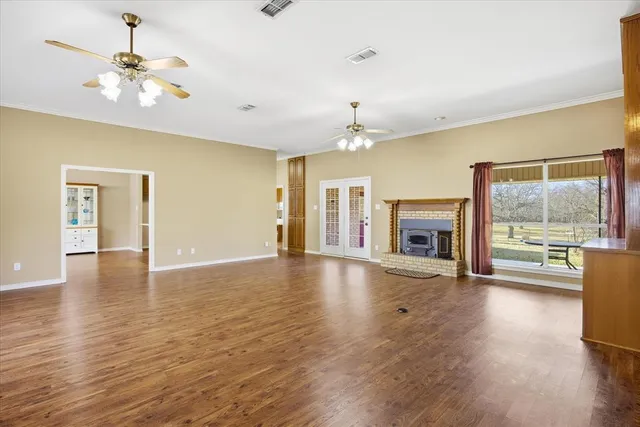 wooden floor fireplace and windows in an empty room