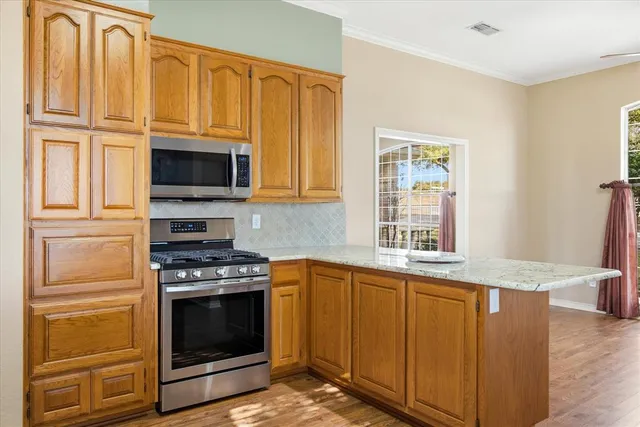 a kitchen with granite countertop a stove top oven microwave and cabinets
