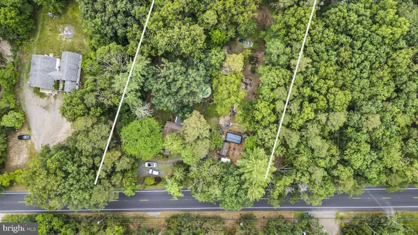 an aerial view of a house with a yard and large trees