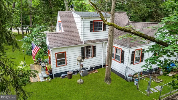 a view of a house with a backyard and a tree