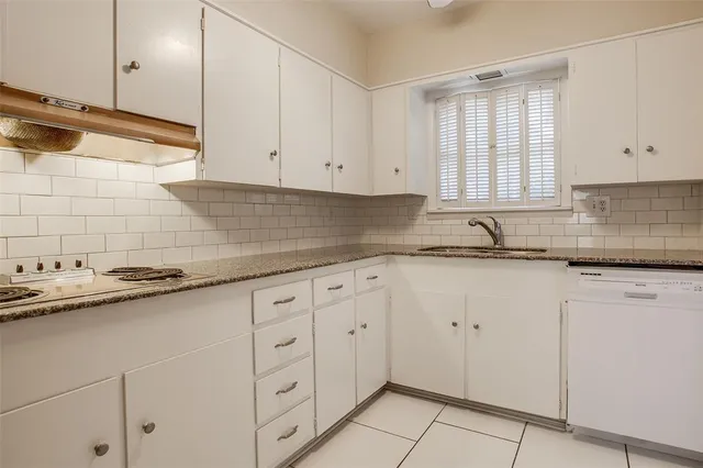 a kitchen with granite countertop white cabinets and white appliances
