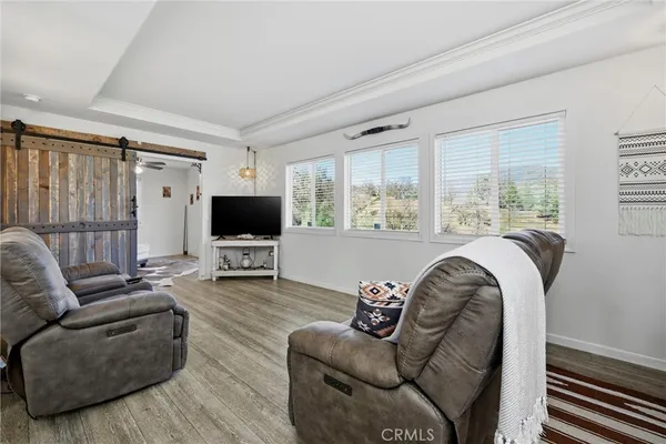 a living room with furniture a flat screen tv and a window