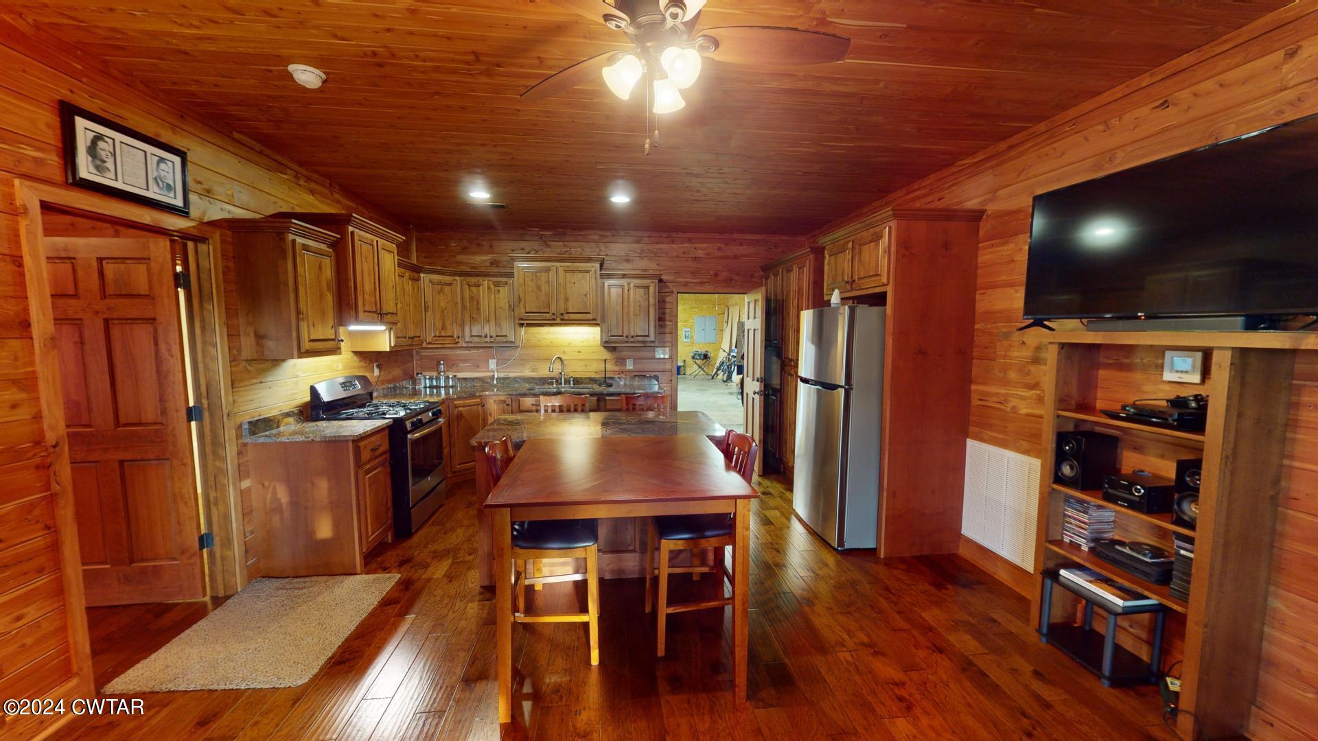 5334 Ira Barker Road Obion, TN 38240 - Photo 26 of 68 a kitchen with stainless steel appliances granite countertop a refrigerator a stove and a dining table with wooden floor