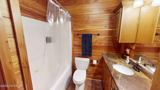 a front view of house with yard and trees in the background