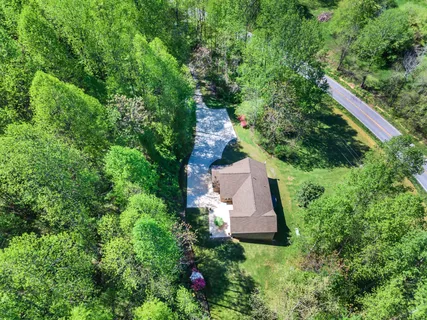 an aerial view of a house with a yard and large trees