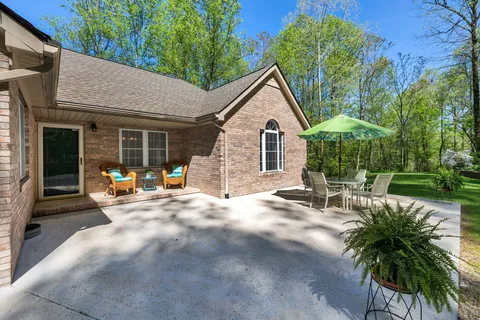 a view of a yard with a table and chairs under an umbrella