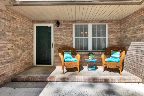 a view of a hallway with wooden floor and a living room