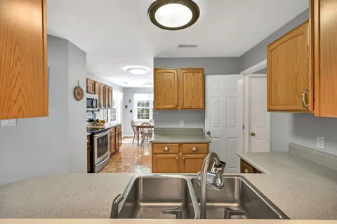 a kitchen with stainless steel appliances granite countertop a stove a sink and a microwave