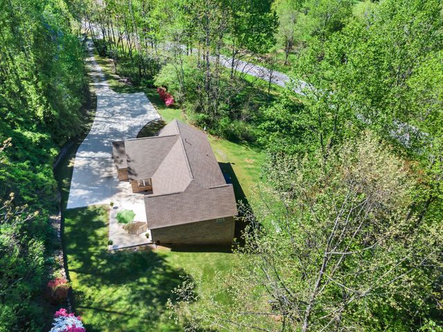an aerial view of a house with a yard and large trees