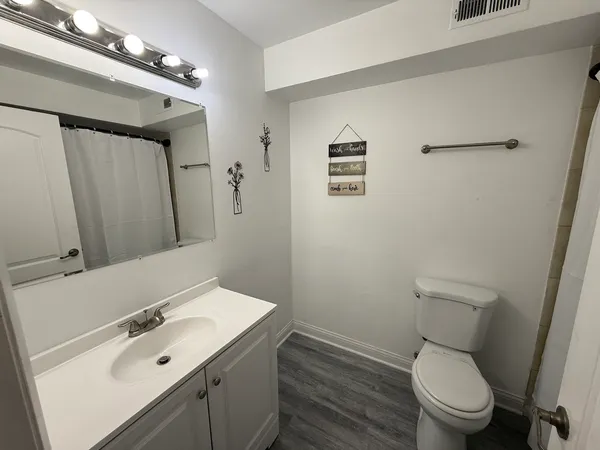 a bathroom with a sink mirror vanity and toilet