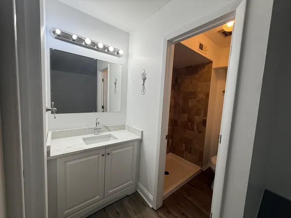 a en suite bathroom with a sink a mirror and shower