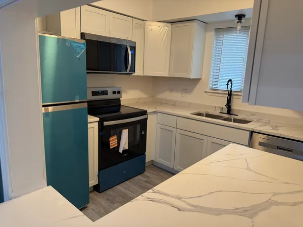 a kitchen with stainless steel appliances kitchen island a sink stove and microwave