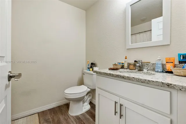 a bathroom with a granite countertop toilet sink and a mirror