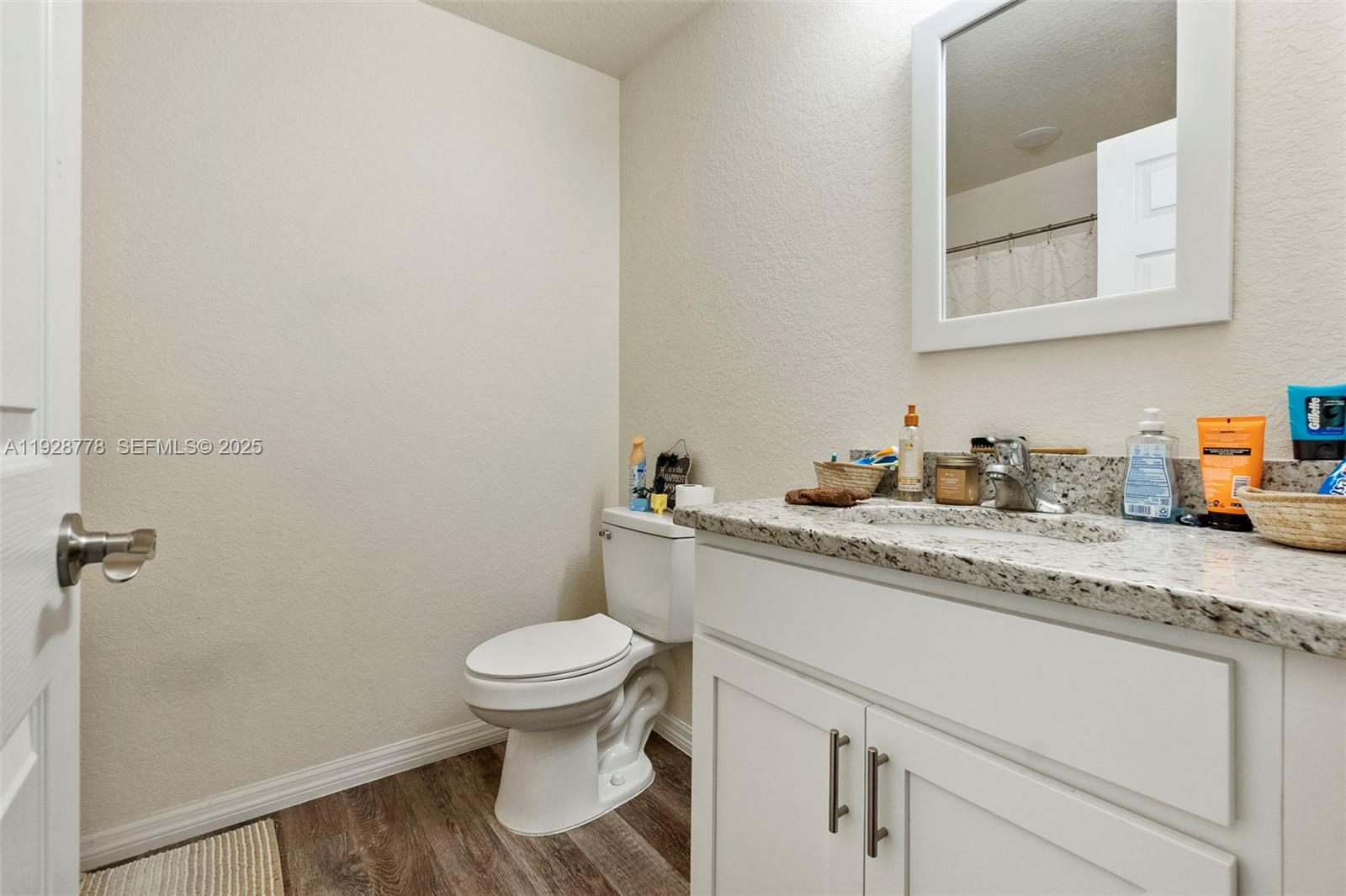 3019 Honeywood Road LaBelle, FL 33935 - Photo 15 of 18 a bathroom with a granite countertop toilet sink and a mirror