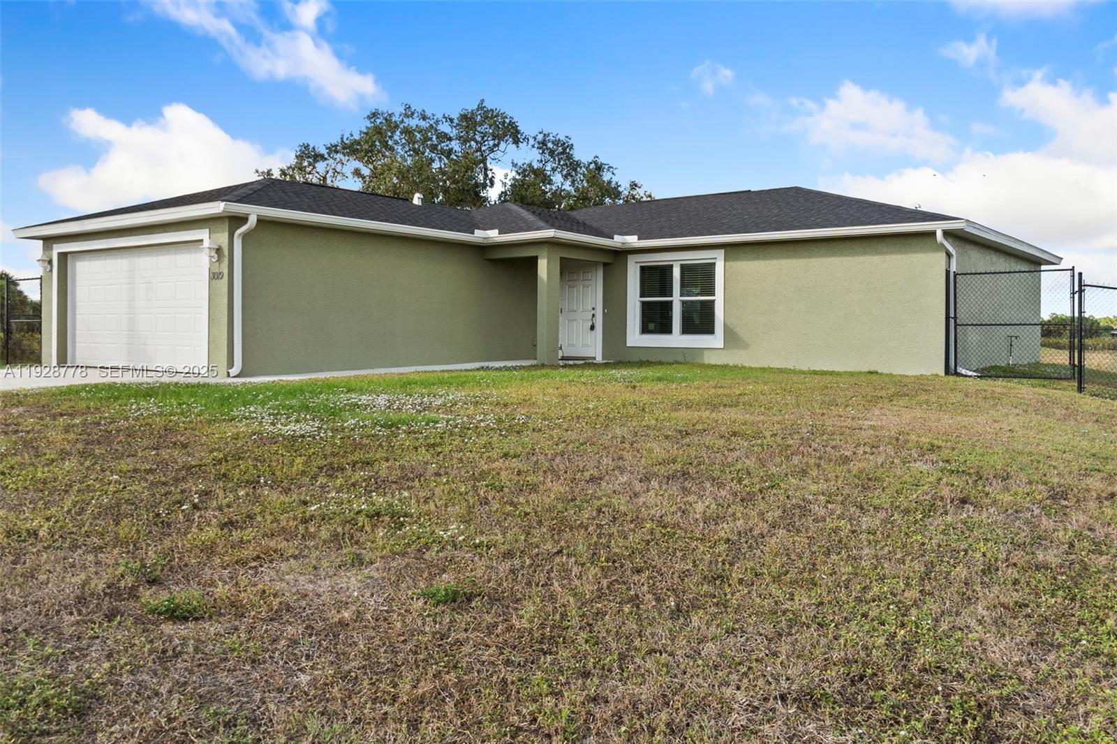 3019 Honeywood Road LaBelle, FL 33935 - Photo 2 of 18 a house that has a tree in front of it