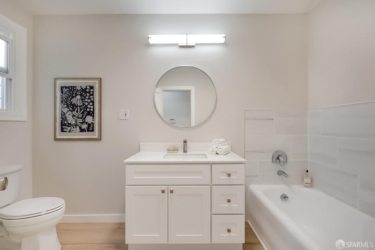 1674 25th Avenue San Francisco, CA 94122 - Photo 12 of 42 a bathroom with a toilet a sink and mirror