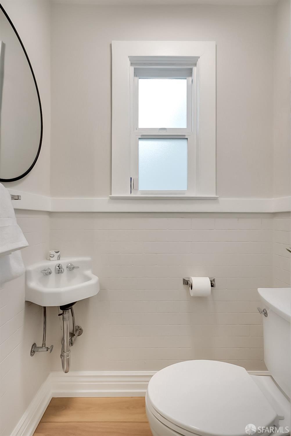1674 25th Avenue San Francisco, CA 94122 - Photo 17 of 42 a bathroom with a sink a mirror and a toilet