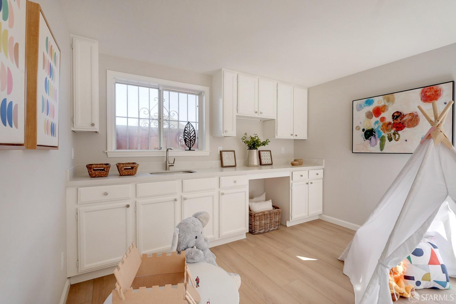 1674 25th Avenue San Francisco, CA 94122 - Photo 28 of 42 a large white kitchen with a sink and cabinets