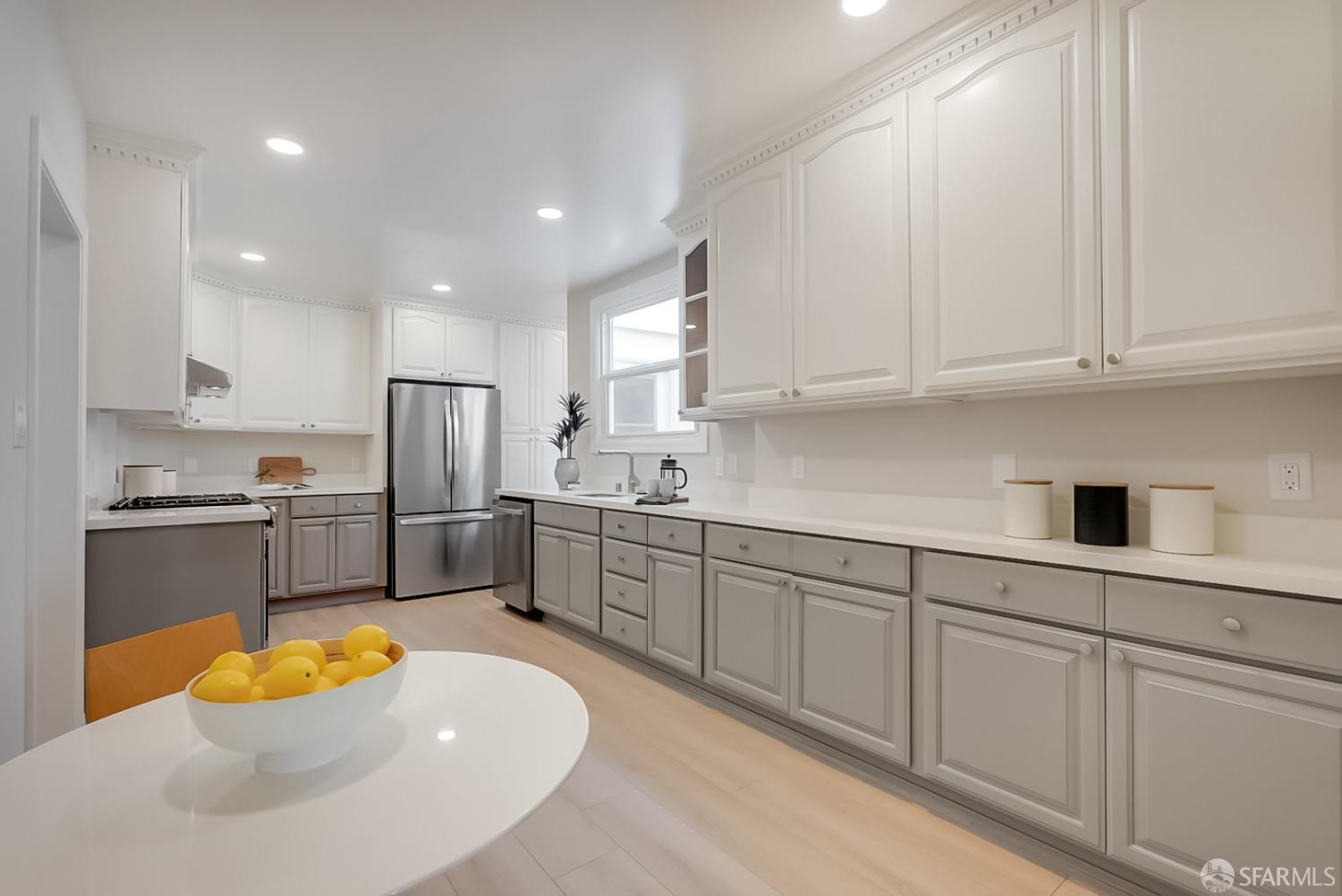 1674 25th Avenue San Francisco, CA 94122 - Photo 6 of 42 a kitchen with stainless steel appliances granite countertop a sink a stove a refrigerator and white cabinets