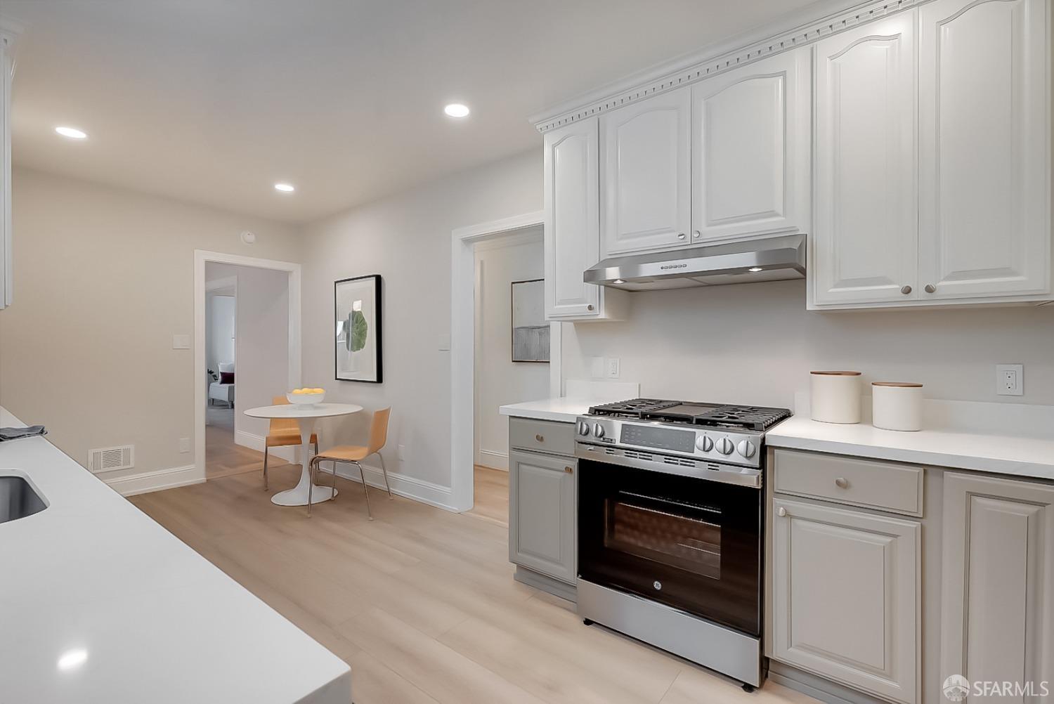 1674 25th Avenue San Francisco, CA 94122 - Photo 8 of 42 a kitchen with stainless steel appliances granite countertop a stove a white cabinets and a sink