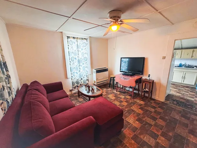 a living room with furniture a flat screen tv and a window