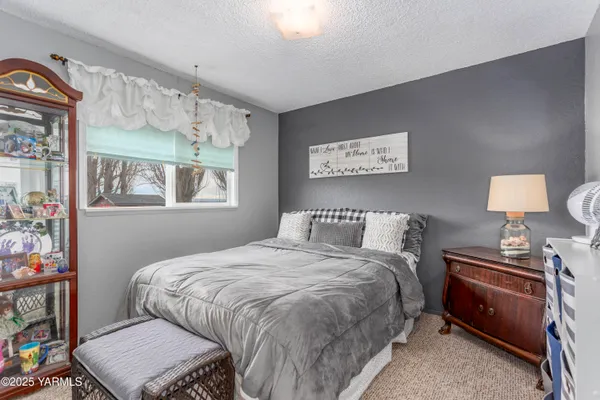 a bedroom with a bed bookshelf and a window