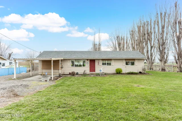 a front view of a house with a garden and trees