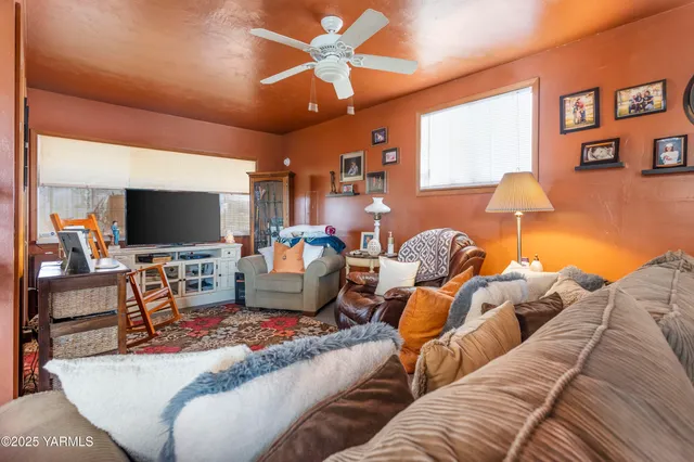 a living room with furniture a flat screen tv and a lamp