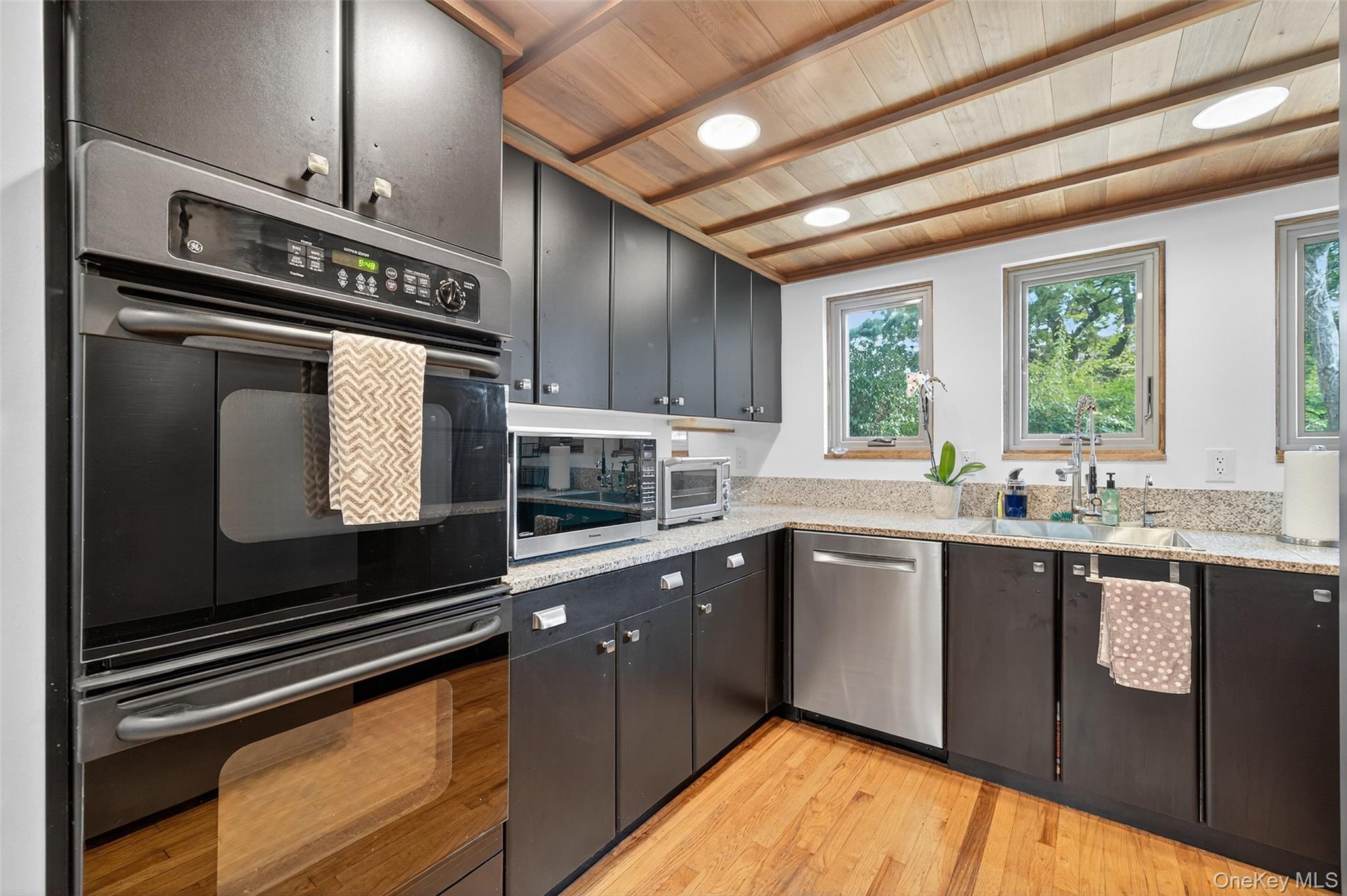 441 Scotchtown Collabar Road Middletown, NY 10941 - Photo 17 of 48 Kitchen featuring stainless steel appliances, wooden ceiling, light wood finished floors, dark cabinets, and light stone countertops