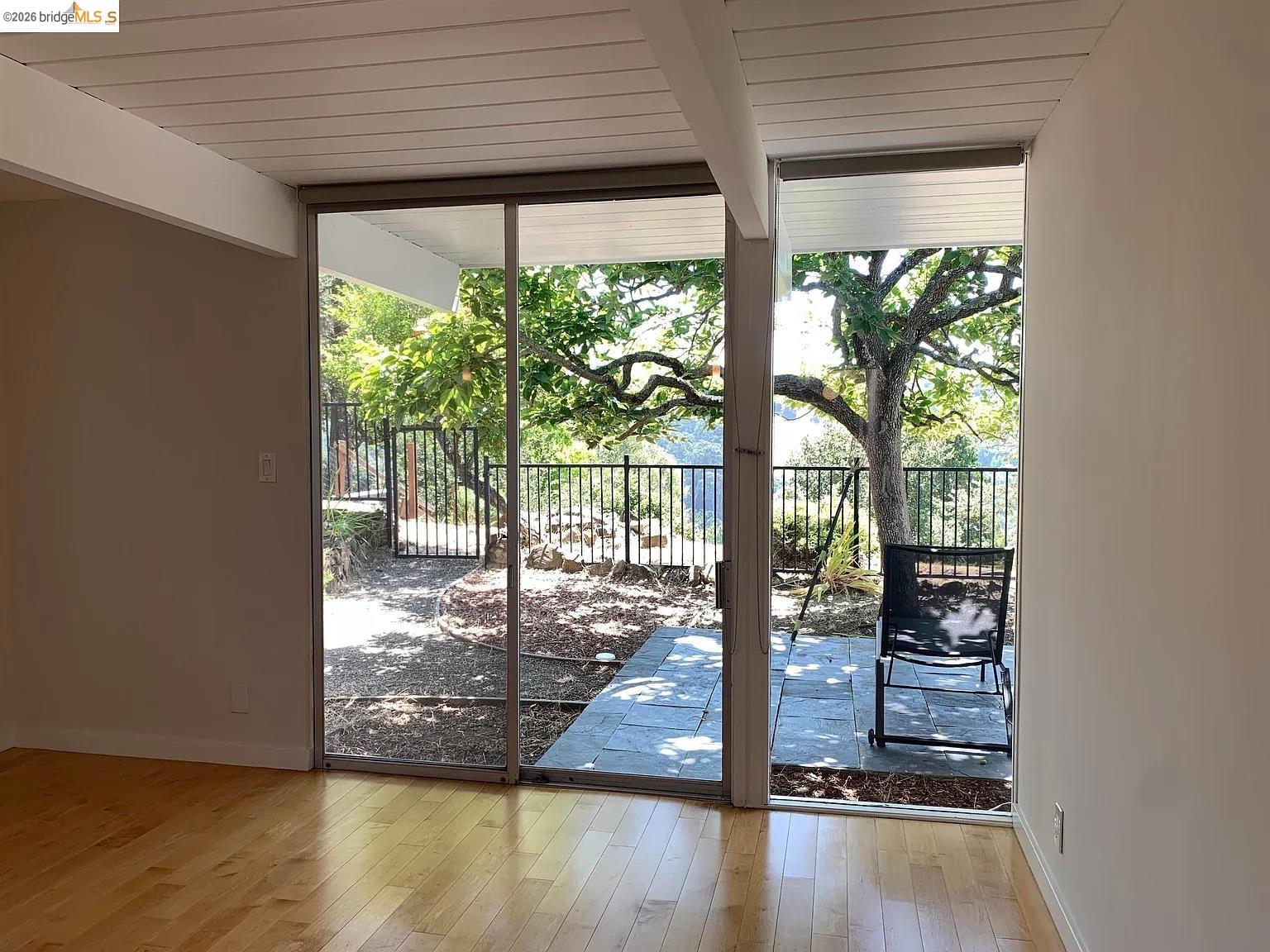 5559 Greenridge Road Castro Valley, CA 94552 - Photo 14 of 33 Doorway with expansive windows, plenty of natural light, hardwood / wood-style flooring, and beamed ceiling