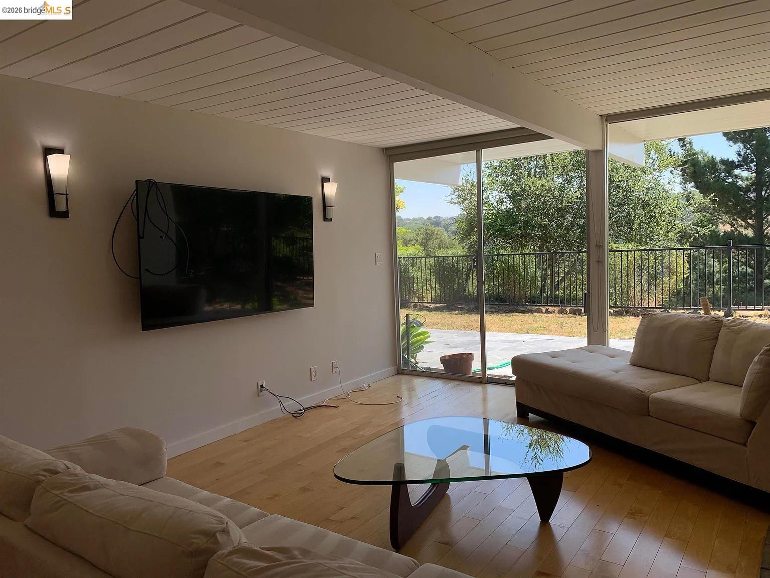 5559 Greenridge Road Castro Valley, CA 94552 - Photo 21 of 33 Living room featuring expansive windows, hardwood / wood-style floors, and a wooden ceiling with exposed beams