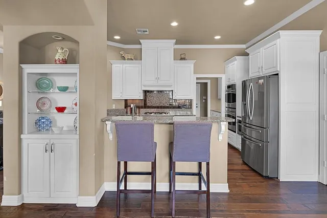 a kitchen with stainless steel appliances granite countertop a refrigerator and a stove top oven