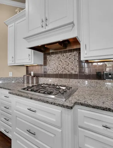a kitchen with granite countertop white cabinets and white appliances
