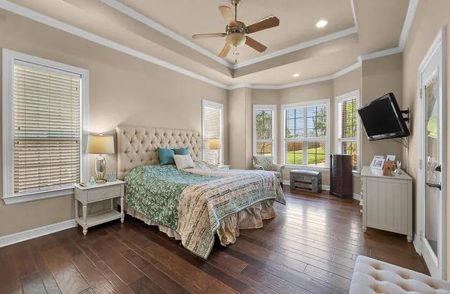 a bedroom with a bed a flat screen tv and a couch